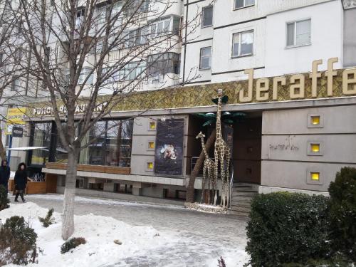 een winkel voor een gebouw in de sneeuw bij Stylish apartment on street Ismail 84 in Chişinău