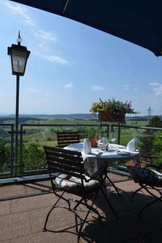 a table and chairs on a balcony with a view at Landhaus Waldfrieden in Tengen
