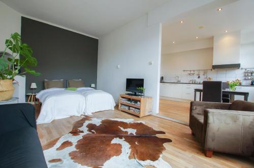 a large room with a bed and a living room at Apartment Havenstraat in Delft