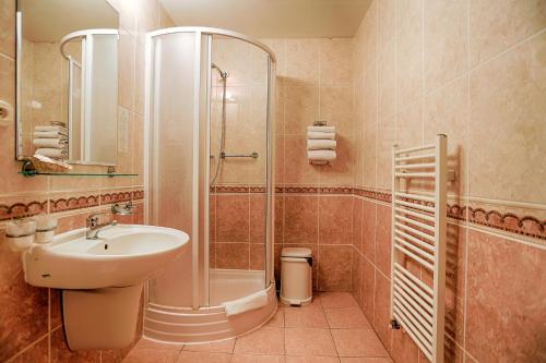 a bathroom with a sink and a shower at Ensana Vila Trajan in Piešťany