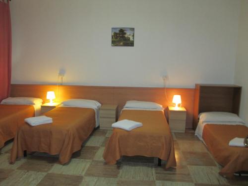 Habitación con 3 camas y 2 lámparas en Hostel 3, en Milán