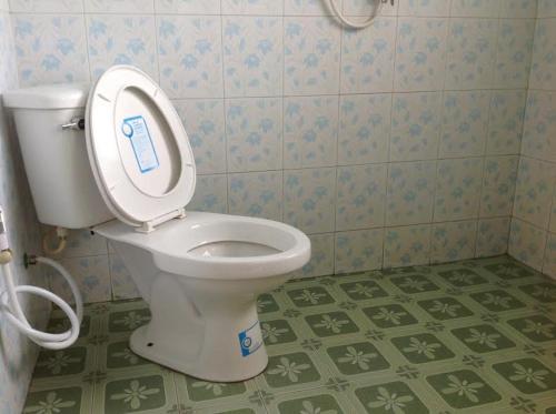 a bathroom with a toilet with the lid up at Family Tanotebay Resort in Koh Tao