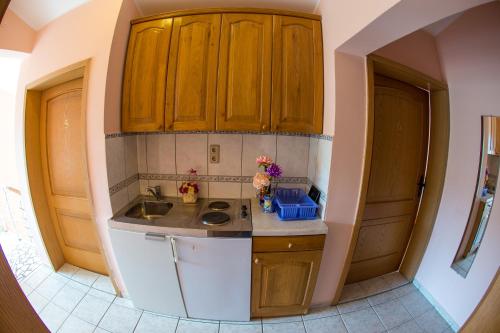 eine kleine Küche mit Holzschränken und einem Waschbecken in der Unterkunft Guest House Almond in Becici
