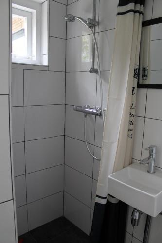 un baño con ducha y lavabo en Zeeland aan Zee, en Burgh Haamstede