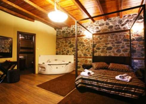 Habitación con cama y bañera. en Gioras Hotel, en Palaios Agios Athanasios