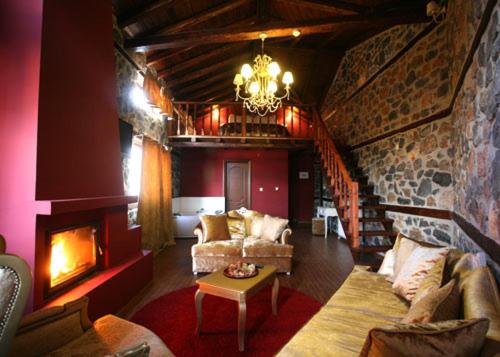 a living room with a couch and a fireplace at Gioras Hotel in Palaios Agios Athanasios