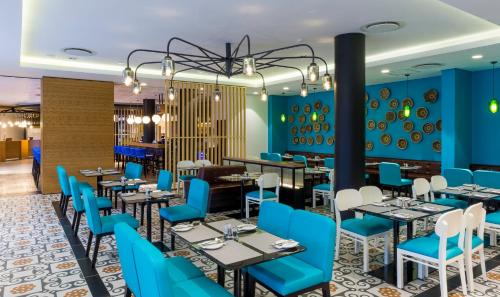 a restaurant with blue walls and tables and blue chairs at Park Inn by Radisson Polokwane in Polokwane
