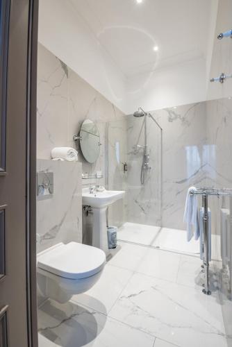 a white bathroom with a toilet and a sink at Château de Montabert in Montaulin
