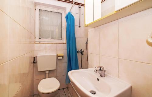 a bathroom with a sink and a toilet and a window at Apartments ZZ in Posedarje