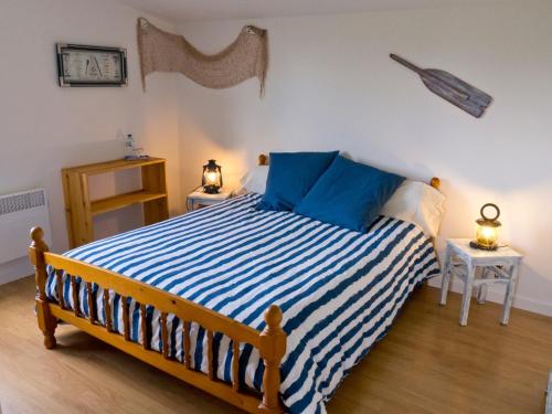 a bedroom with a large bed with blue and white stripes at Châtelet Camelot in Plouha