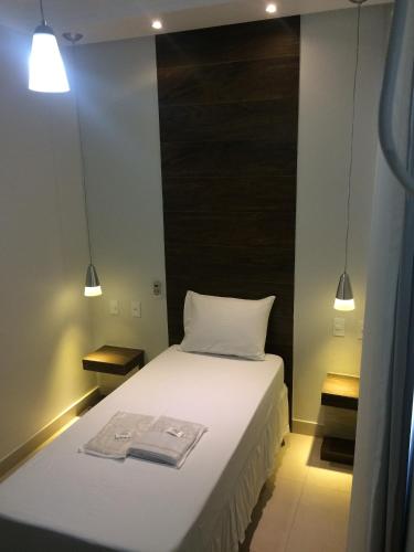 a bedroom with a bed with two towels on it at Hotel Beira Rio in Teófilo Otoni