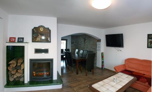a living room with a fireplace and a dining room at Apartments Stein in Boží Dar