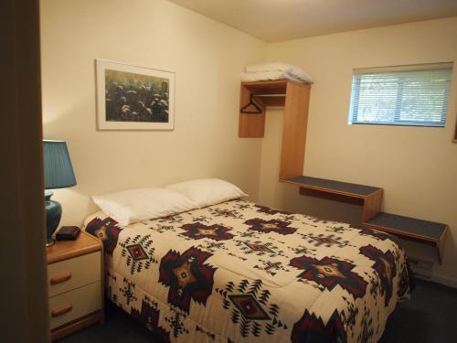 a bedroom with a bed with a horse blanket at Whale's Tail Guest Suites in Ucluelet