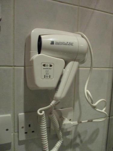 a phone hanging on a wall in a bathroom at Executives Hotel - Azizia in Riyadh