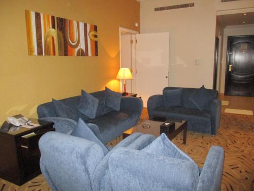 a living room with two blue couches and a table at Executives Hotel - Azizia in Riyadh