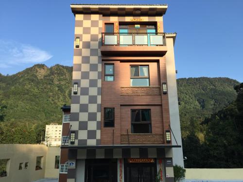 a tall building with a checkerboard pattern on it at Sin Ging Hong Resort in Lugu