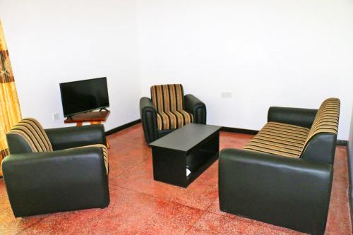 a living room with chairs and a table and a tv at Lavish Eco Jungle in Tissamaharama