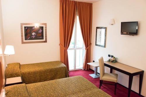 a hotel room with a bed and a desk at Hotel Fontanelle in Fratta Terme