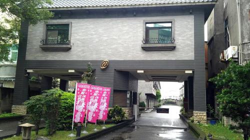 un edificio con una señal rosa delante de él en North Country Motel en Yingge
