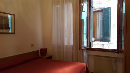 1 dormitorio con cama y ventana en rialto1082, en Venecia