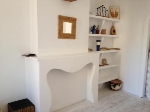 una chimenea blanca en una habitación con estanterías blancas en La planque, en Gruissan