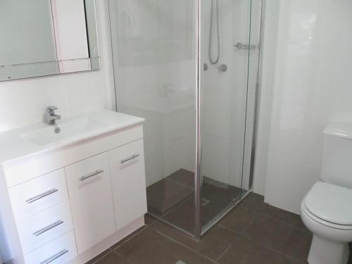 a bathroom with a shower and a sink and a toilet at Costa D'Ora Holiday Apartments in Gold Coast