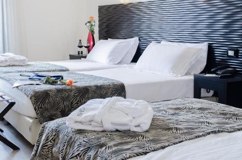a hotel room with three beds with towels on them at Hotel Garibaldi in Palermo