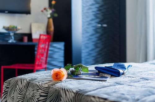a flower on a bed with a tray of food at Hotel Garibaldi in Palermo