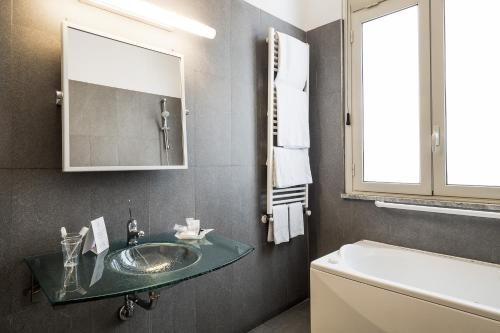 Un baño con lavabo, espejo y bañera. en Hotel Garibaldi, en Palermo