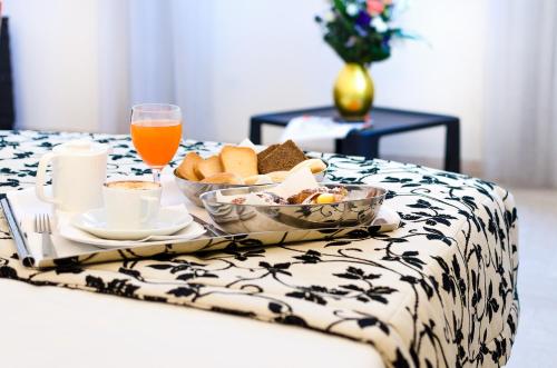 a breakfast tray with bread and orange juice on a bed at Hotel Garibaldi in Palermo