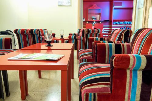 a waiting room with chairs and a wooden table and a table and chairs at Hotel Garibaldi in Palermo