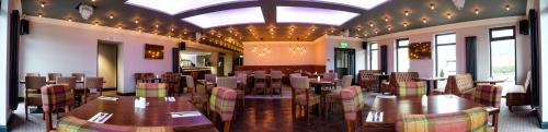 a restaurant with tables and chairs in a room at Adamson Hotel in Dunfermline