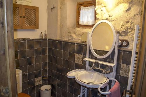 uma casa de banho com um lavatório e um espelho em La Antigua casa del cartero em Roda de Eresma