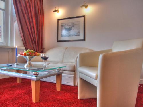 a living room with a couch and a table at Vogel Hotel & Appartements in Warnemünde