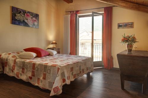 a bedroom with a bed and a large window at B&B Doria Valle Maira in Roccabruna