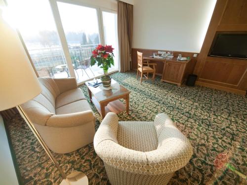 a living room with two couches and a television at Gartenhotel & Weingut Pfeffel Dürnstein in Dürnstein