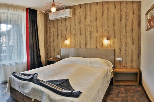 a bedroom with a large bed with a wooden wall at Black Sea Royal Villa in Rogachevo