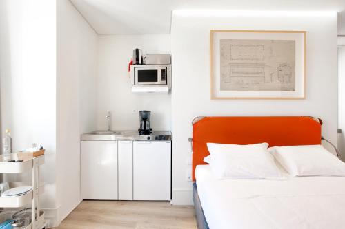a bedroom with a white bed and white walls at Ascensor da Bica - Lisbon Serviced Apartments in Lisbon