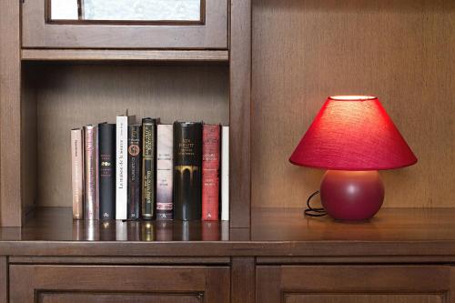 a red lamp sitting on a shelf with books at B&B Doria Valle Maira in Roccabruna