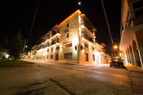 a lit up building on a street at night at Filoxenia Hotel & Spa in Kalavrita