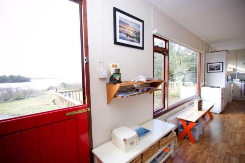 a room with a red door and a desk and a window at Erinona Chalet in Kesh