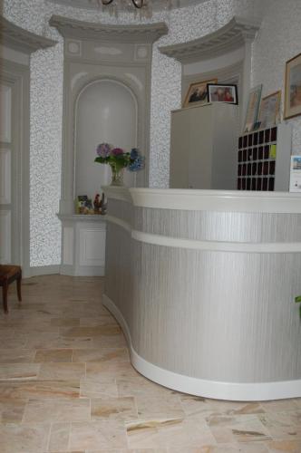 a lobby of a pharmacy with a counter and flowers at Logis Hotel L'europe in Pontivy