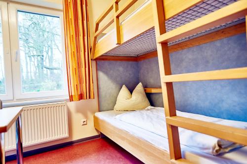 a bedroom with two bunk beds and a window at Jugendherberge Jever in Jever