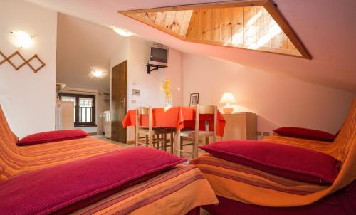 a bedroom with two beds and a dining room at Ca Serena Mansarda in Ledro
