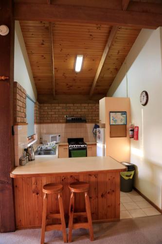 a kitchen with a counter and two stools in it at Jamieson Valley Retreat in Howqua