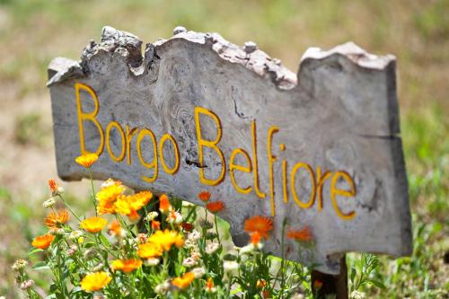 a sign that says bone bridge in a field of flowers at Borgo Belfiore in Arcevia