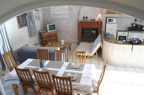 cocina y comedor con mesa y sillas en Gîtes du Vieux Presbytère, en Baguer-Pican
