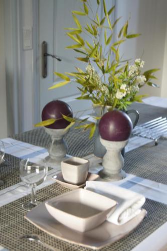 une table avec une plaque et un vase sur elle dans l'établissement Gîtes du Vieux Presbytère, à Baguer-Pican