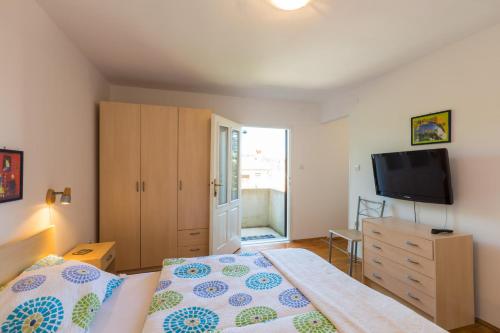 a bedroom with a bed and a flat screen tv at Aloe in Mali Lošinj
