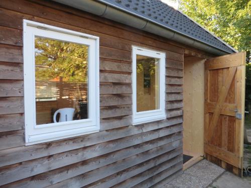 two windows on the side of a log cabin at Casa Koudekerke in Koudekerke